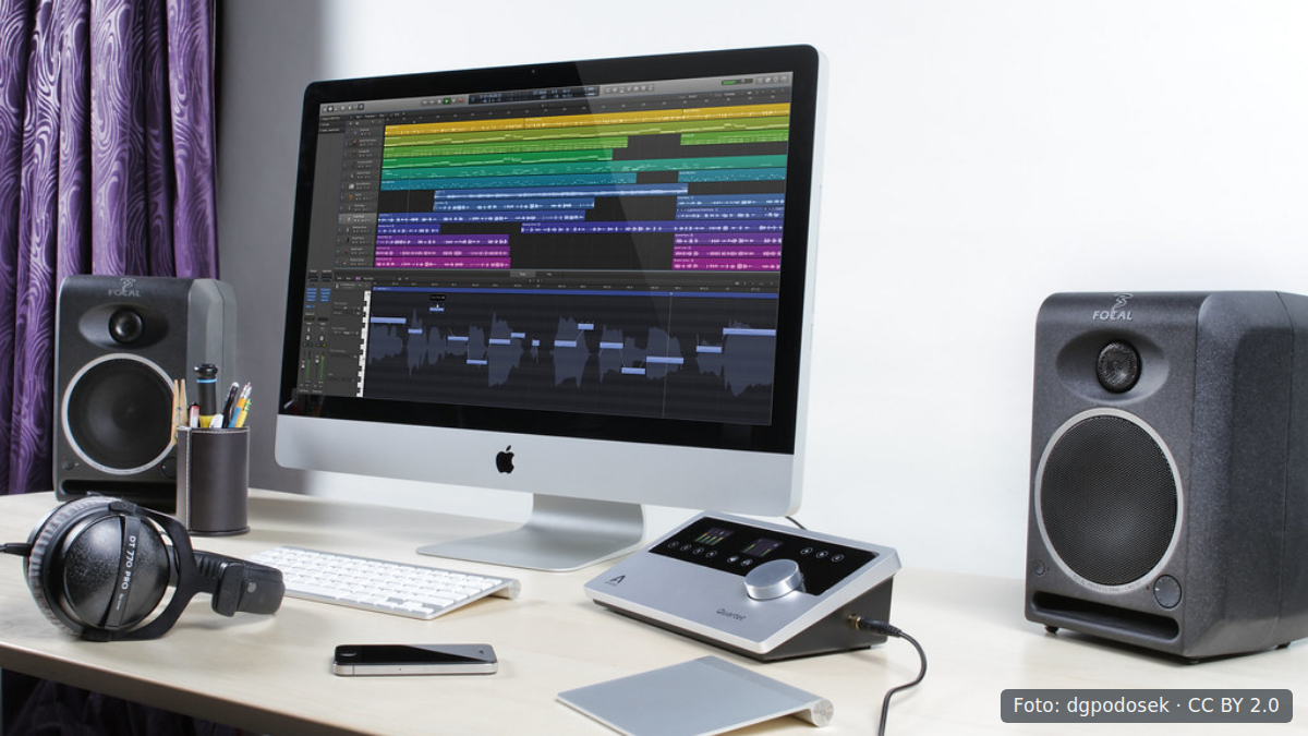 Bureau met computer en muziekproductiesoftware in kleine studio